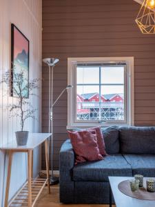 salon z kanapą i oknem w obiekcie Authentic Lofoten Rorbu w mieście Stamsund