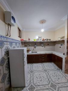 a kitchen with a refrigerator and a tile floor at RESIDENCE ABOU YASSINE in Dakhla