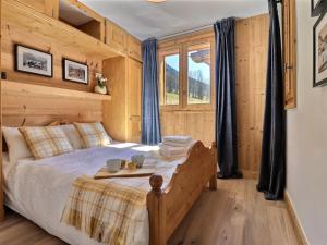 a bedroom with a bed in a room with wooden walls at Chalet Morzine, 7 pièces, 8 personnes - FR-1-627-23 in Morzine