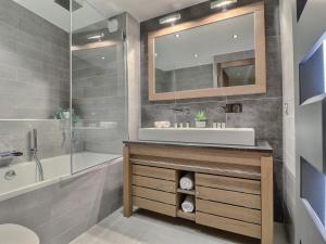 a bathroom with a sink and a tub and a mirror at Appartement Morzine, 4 pièces, 9 personnes - FR-1-627-27 in Morzine