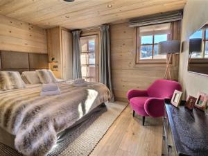 um quarto com uma cama grande e uma cadeira rosa em Chalet Les Gets, 7 pièces, 12 personnes - FR-1-627-6 em Les Gets