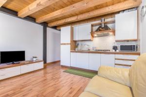 eine Küche und ein Wohnzimmer mit weißen Schränken und einem TV in der Unterkunft Casa Giuly in Mirano