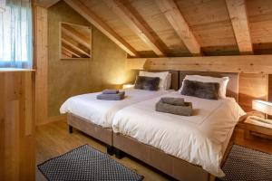 sypialnia z 2 łóżkami w pokoju z drewnianym sufitem w obiekcie Chocolat Manigod - OVO Network w mieście Manigod