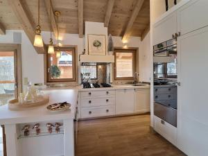 a kitchen with white cabinets and a wooden ceiling at Chalet Morzine, 7 pièces, 12 personnes - FR-1-627-20 in Morzine