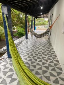 a hammock on a porch with a tiled floor at Casa Enseada dos Corais in Cabo de Santo Agostinho