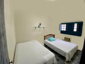 a room with two beds and a window at Casa Enseada dos Corais in Cabo de Santo Agostinho