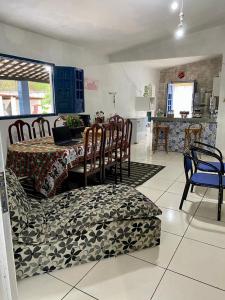 a dining room with a table and chairs and a kitchen at Casa Enseada dos Corais in Cabo de Santo Agostinho