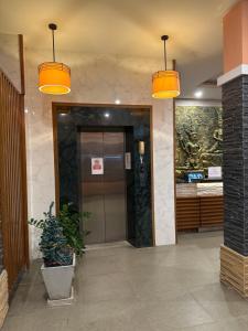 a lobby with a elevator and two lights at The Prisha inn in Patong Beach