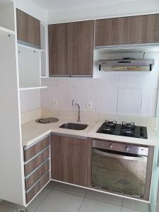 a small kitchen with a sink and a stove at Apartamento fino e decorado. in Lauro de Freitas