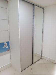 uma porta de vidro deslizante num quarto com um espelho em Apartamento fino e decorado. em Lauro de Freitas