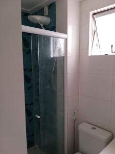 a bathroom with a shower with a toilet and a window at Apartamento fino e decorado. in Lauro de Freitas