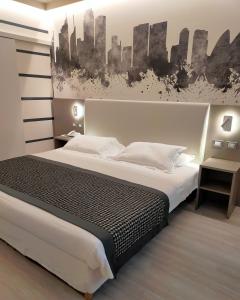 a bedroom with a large bed with a black and white painting at The Sydney Hotel in Bologna