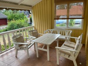 weranda ze stołem i krzesłami na balkonie w obiekcie typical Swedish cosy holiday house in Målilla, Småland w mieście Målilla