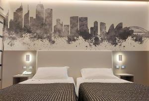 1 dormitorio con 2 camas y una pintura de una ciudad en The Sydney Hotel, en Bolonia
