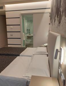 um quarto com quatro camas e um espelho em The Sydney Hotel em Bolonha