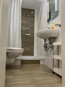 a bathroom with a sink and a shower and a toilet at Ferienwohnung Corona in Forst