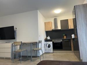 cocina con mesa, sillas y lavavajillas en Ferienwohnung Corona en Forst