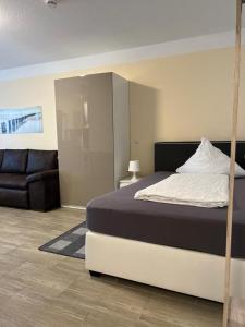 1 dormitorio con 1 cama y 1 sofá en Ferienwohnung Corona en Forst