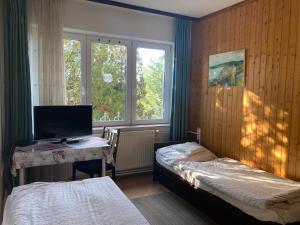 a room with two beds and a desk with a computer at Apartman-Donau Tát in Tát