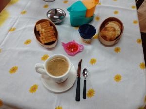 una mesa cubierta con una taza de café y pan en Nuestro Hogar en Malargüe