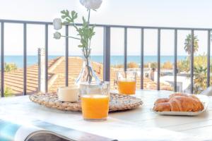 stół ze śniadaniem obejmującym sok pomarańczowy i rogaliki w obiekcie Residence Il Triangolo w mieście Roseto degli Abruzzi