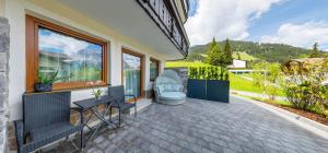 a house with a patio with a table and chairs at BIRKENHOF - Premium Apart & Suites in Lermoos