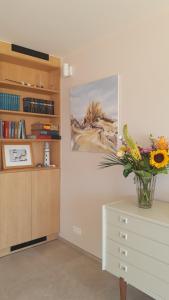 a vase of flowers on a dresser in a room at Valparaiso Koksijde in Koksijde