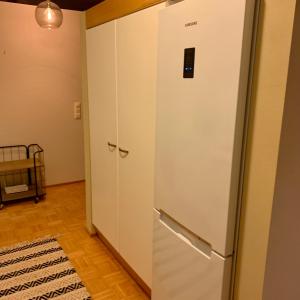 a white refrigerator in a room with a door at Spacious Apartment close to the sea with 2 patios in Pietarsaari