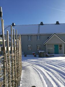 una cerca en la nieve frente a una casa en Stabburet, Lensmannsgården en Namsos