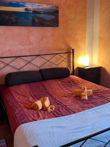 dwa pluszaki leżą na łóżku w obiekcie SantaRufinaHome w mieście LʼAquila