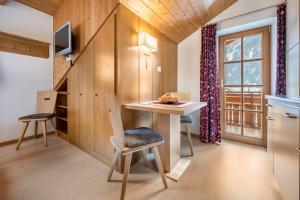 una pequeña cocina con mesa, sillas y ventana en App Nest - Duregger, en Campo Tures