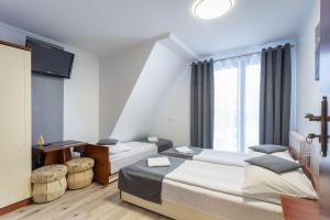 Habitación de hotel con 2 camas y TV en Willa Górska Dolina Jacuzzi & Sauna, en Poronin