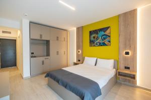 - une chambre avec un grand lit et un mur jaune dans l'établissement Onda Boutique Hotel, à Mamaia Nord – Năvodari