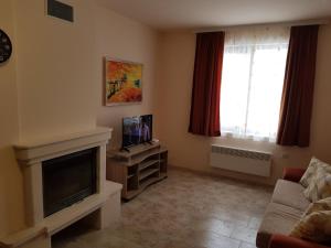 sala de estar con chimenea y TV en Панорама Стойките Релакс, en Stoykite