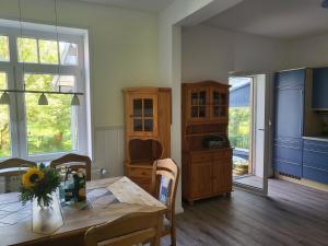 a dining room with a table and a kitchen at Urlaub im blauen Haus in Sehestedt