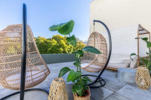 2 chaises en rotin et des plantes sur une terrasse dans l'établissement @ rita'splace, à Faro