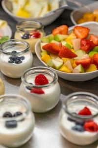 uma mesa coberta com pratos de fruta e iogurte em Abasto Hotel Eichenau em Eichenau