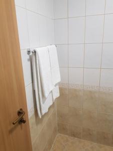 baño con toallas blancas colgadas en la pared en Панорама Стойките Релакс, en Stoykite