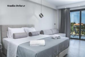 Dionisos Luxury Suites في تسيليفي: غرفة نوم بسرير كبير عليها مناشف