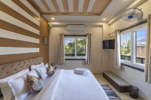 a bedroom with a large bed and two windows at Zostel Bundi in Būndi +91 photos