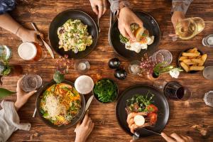 a group of people sitting around a table with plates of food at The Old Success Inn in Sennen Cove