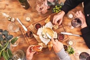 a group of people sitting around a wooden table eating pizza at The Old Success Inn in Sennen Cove