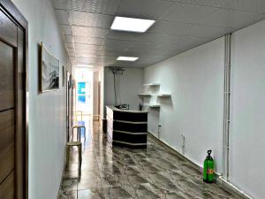 an empty room with a hallway with a counter and chairs at Hotel ZeraVictoria in Atyraū