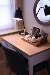 a table with a mirror and a tea kettle on it at The Bell Hotel, Saxmundham in Saxmundham