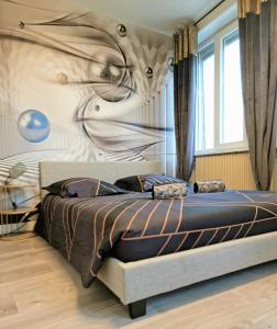 a bedroom with a bed with a painting on the wall at *Le Tendance appart* in Village-Neuf