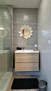 a bathroom with a sink and a mirror at *Le Tendance appart* in Village-Neuf