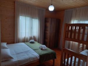 a bedroom with a bed with two towels on it at Wooden House Ashuri in Veltaurtkari