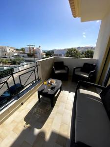 d'un balcon avec des chaises et une table. dans l'établissement Apartamento Mimosas, à Albufeira