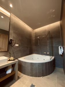 a bathroom with a bath tub and a sink at Irene's Resort in Kato Loutraki