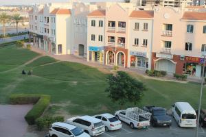 a group of cars parked in a parking lot in front of a building at Bright, spacious and cozy studio apartment in Dubai